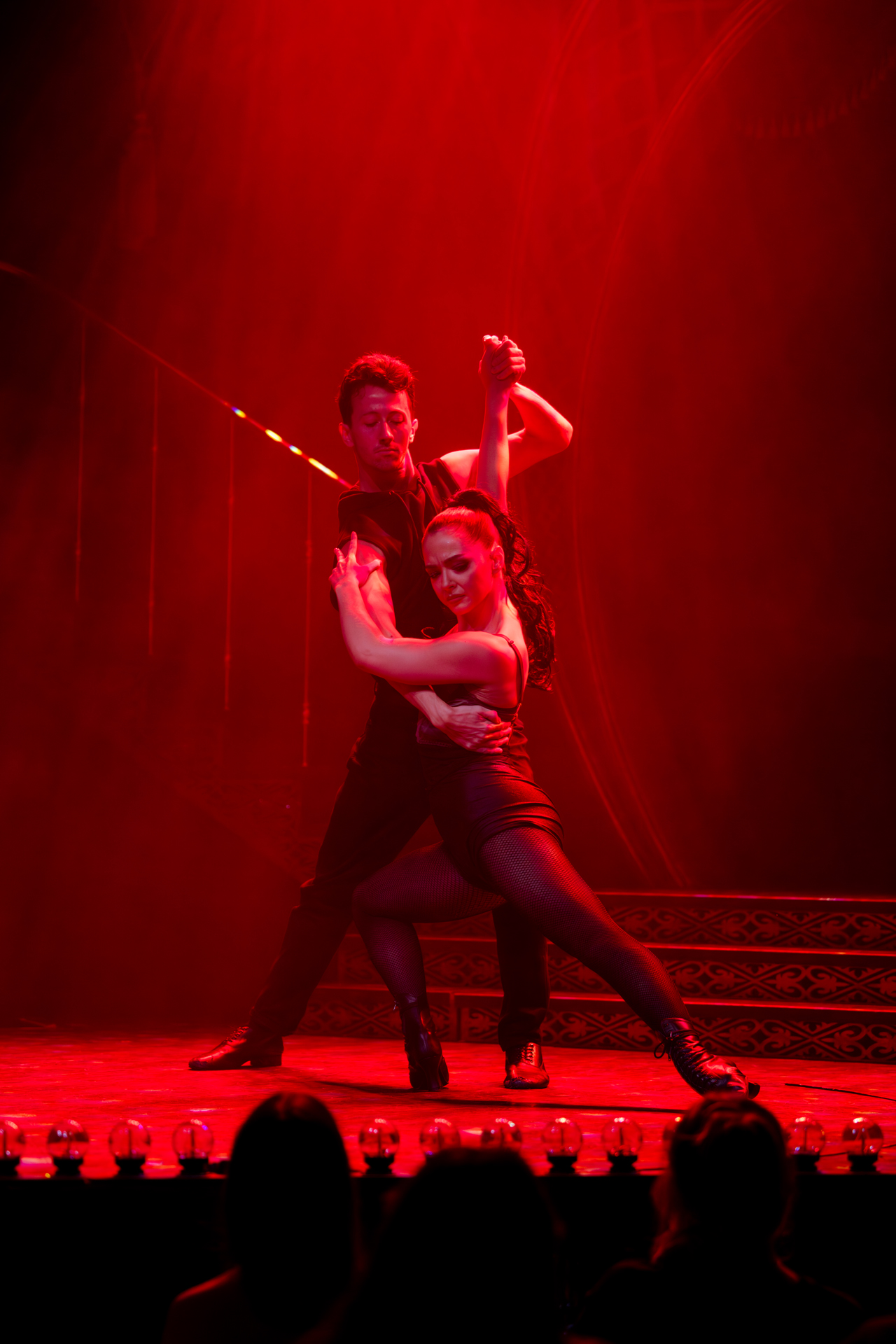 Two dancers dancing the tango on stage as part of the show Adam Garcia's Emerald Storm 