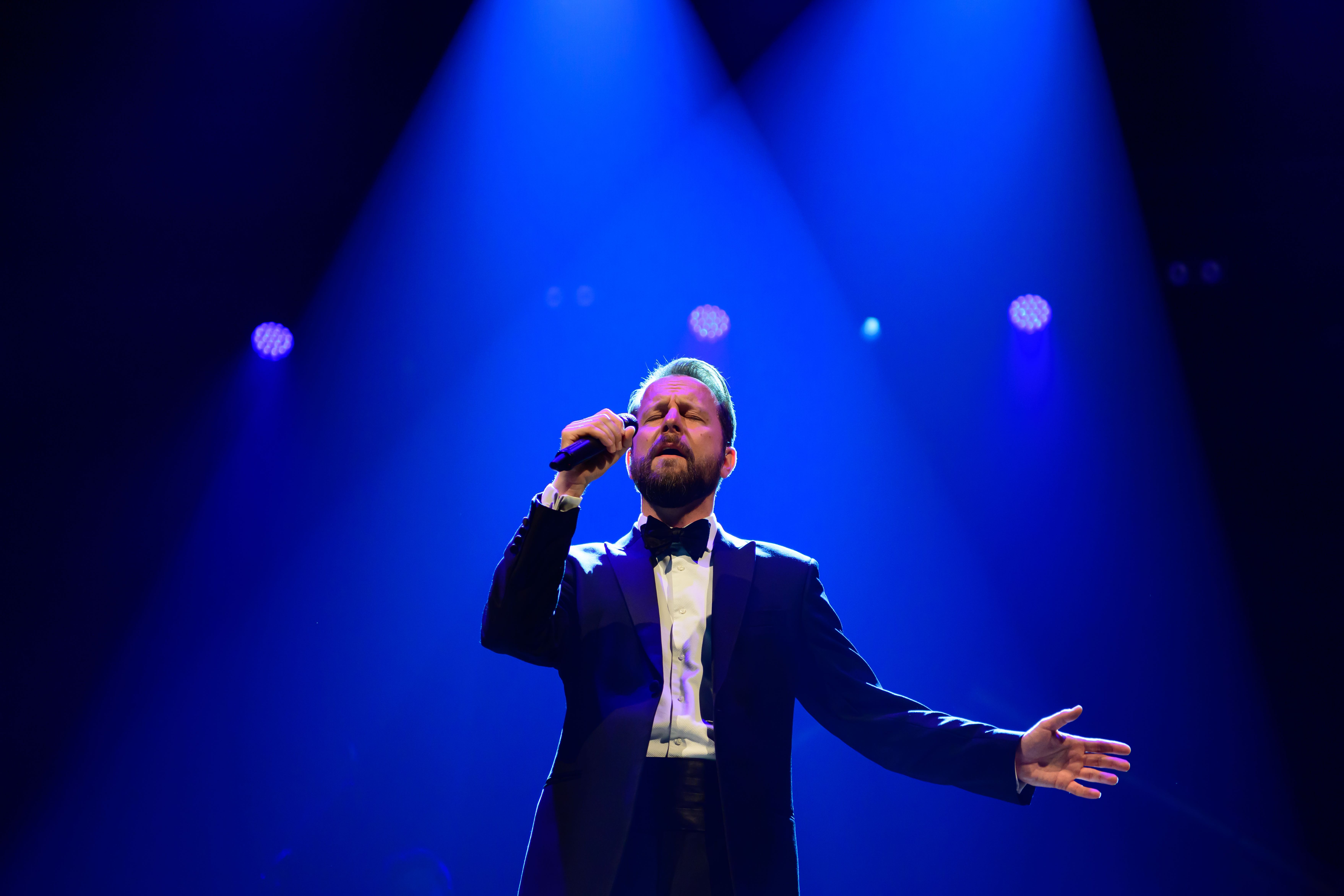 James Bond Themed Concert Spectacular featuring a singer on a theatre stage