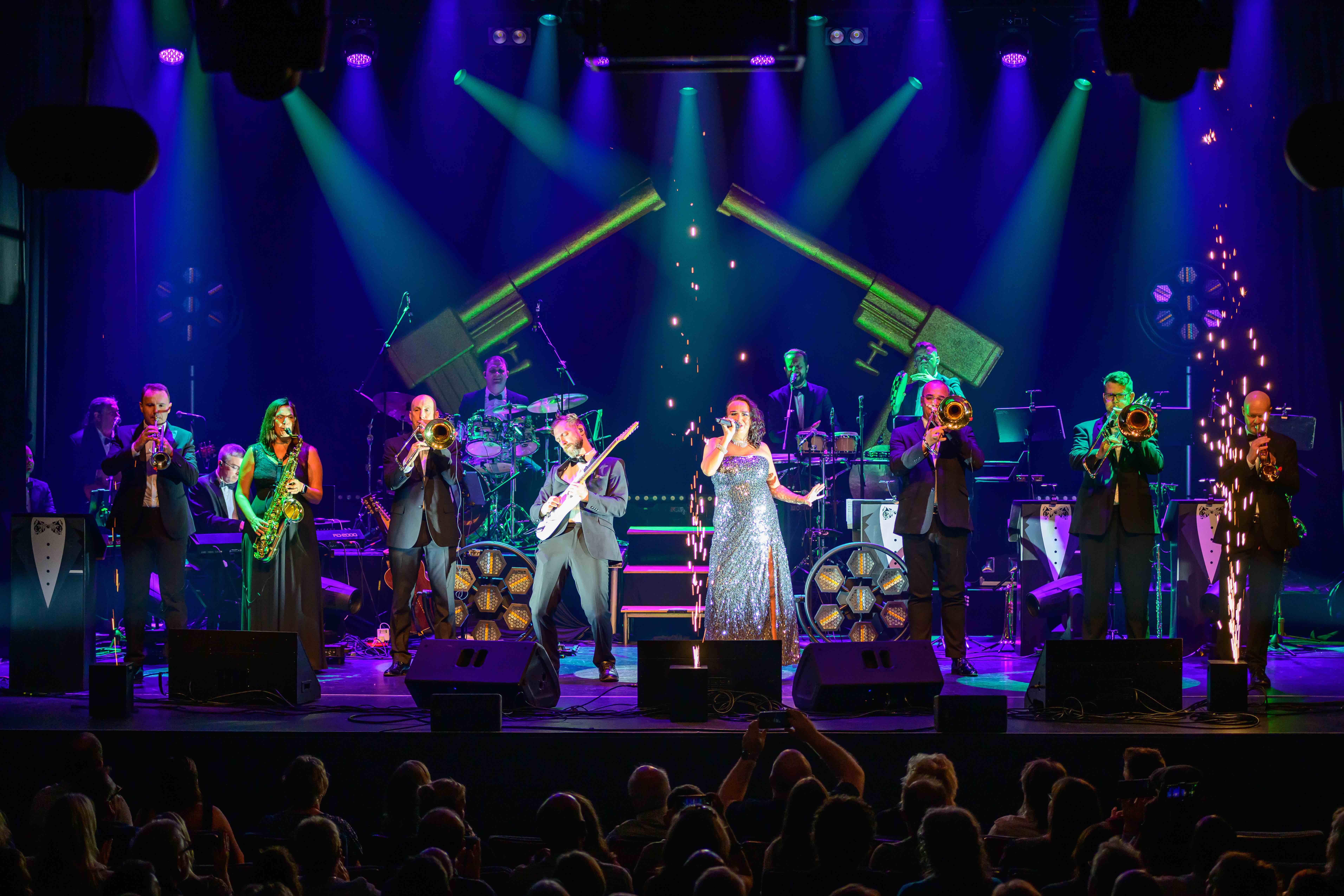 James Bond Themed Concert Spectacular featuring singers and a band on a theatre stage