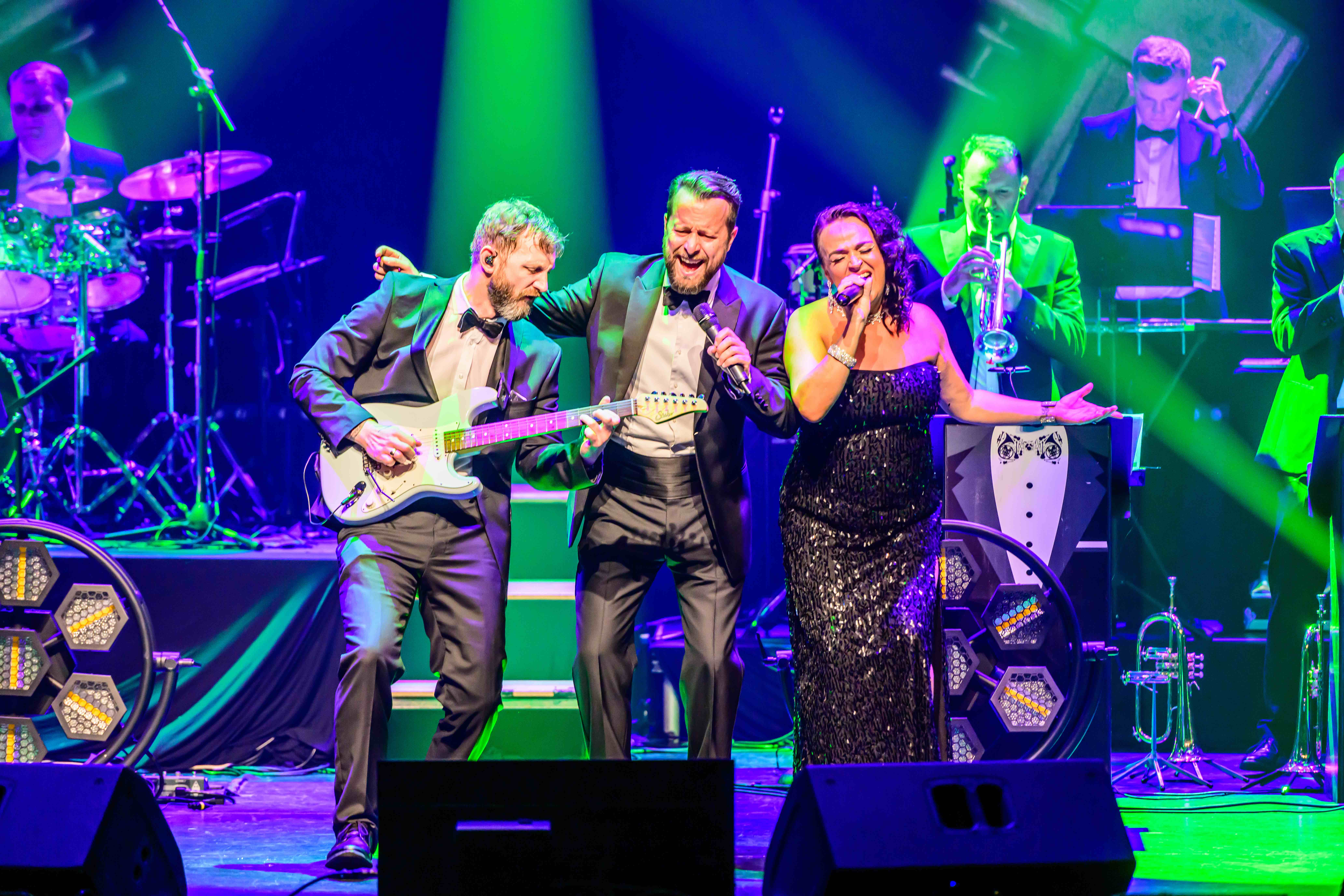 James Bond Themed Concert Spectacular featuring singers and a band on a theatre stage